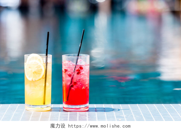 泳池旁的两杯饮品在池畔的美味的红色和橙色鸡尾酒的眼镜特写镜头